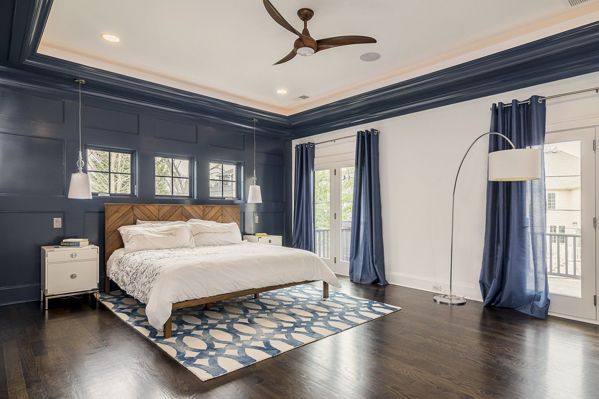 A bedroom with a large bed and a ceiling fan.