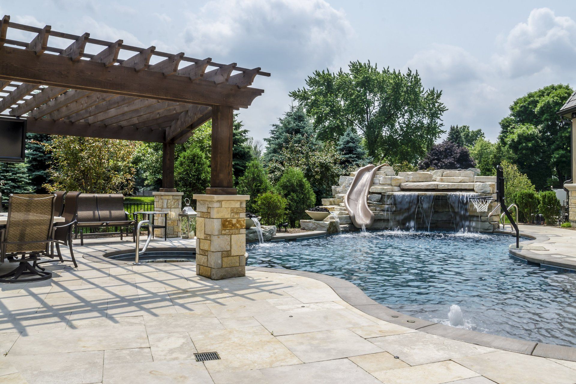 A large swimming pool with a water slide and a pergola