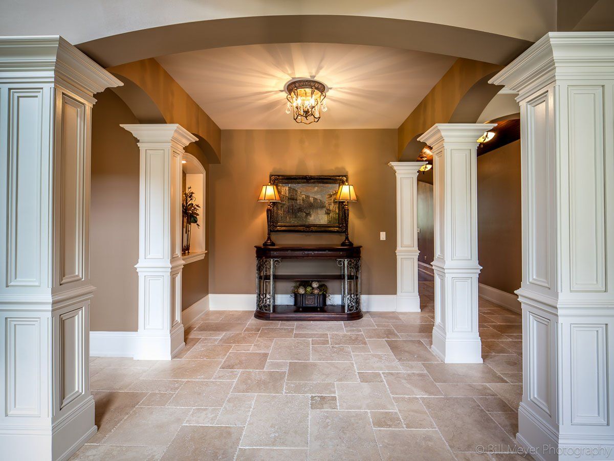 A hallway with columns and a picture on the wall