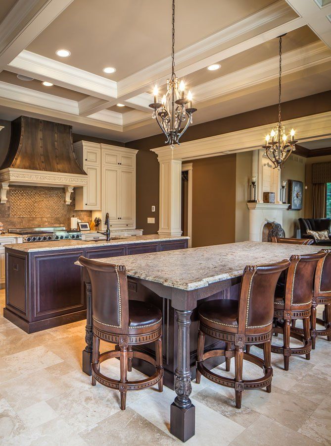 A kitchen with a large table and chairs and a chandelier hanging from the ceiling.