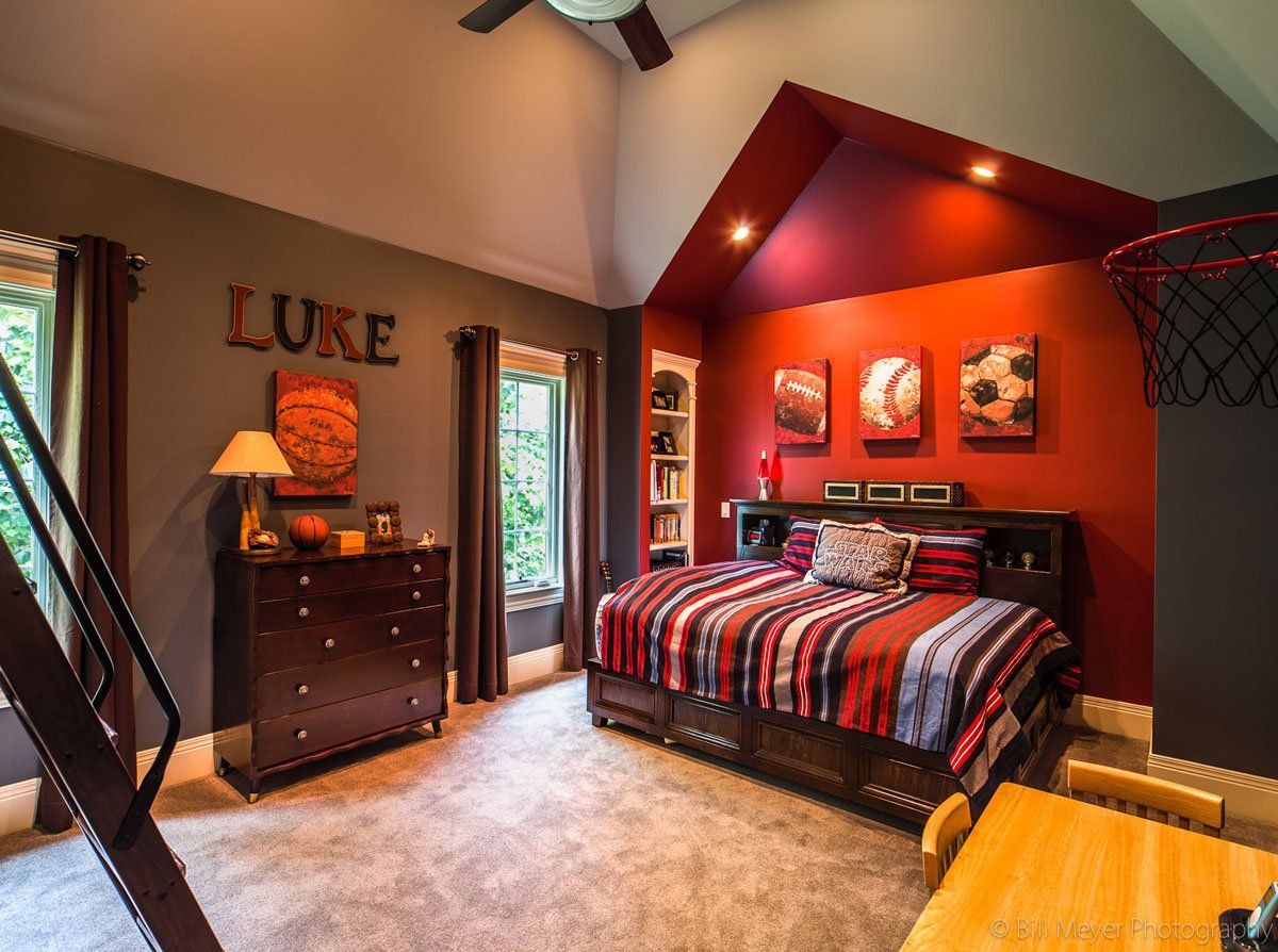 A bedroom with a bed , dresser , and a basketball hoop.