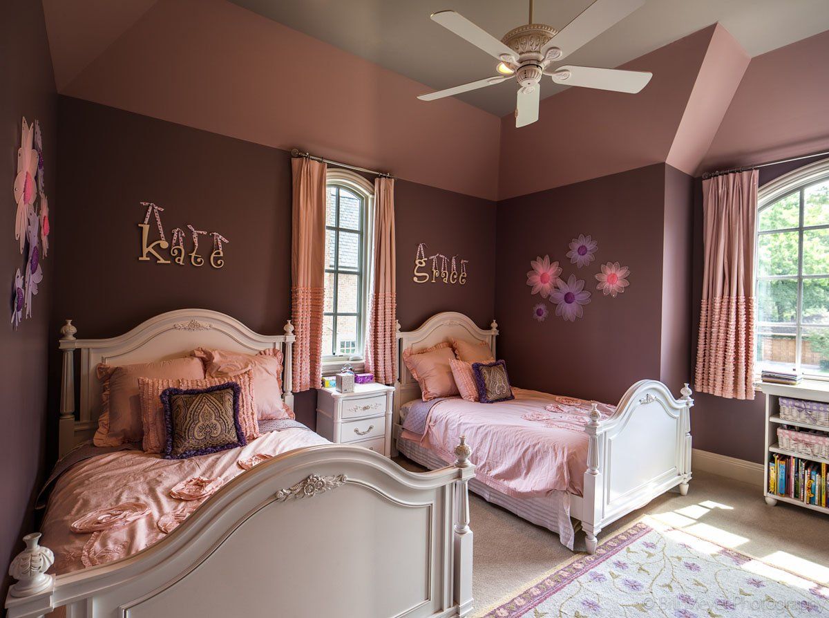 A bedroom with two beds and a ceiling fan.