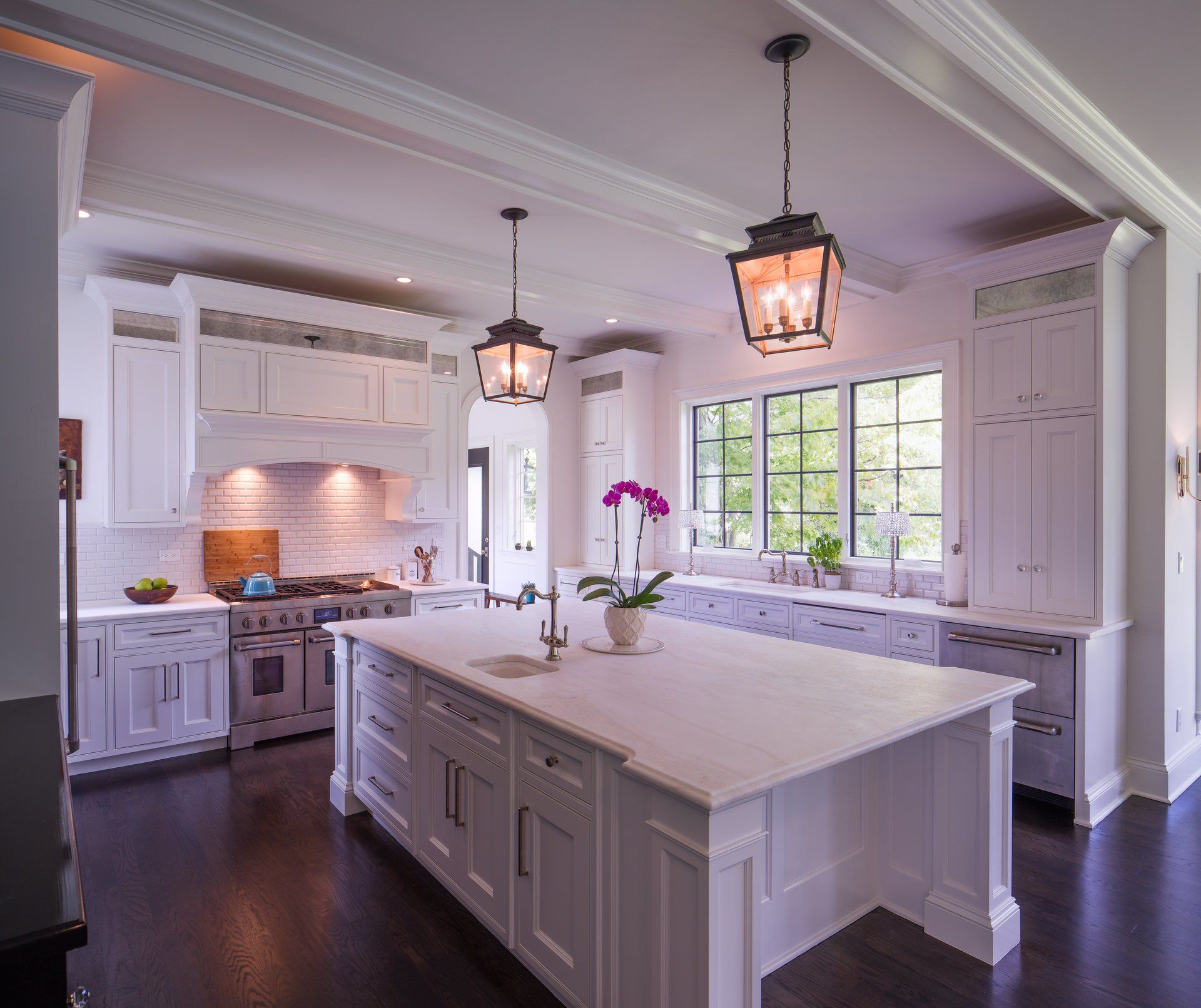 A kitchen with white cabinets and a large island