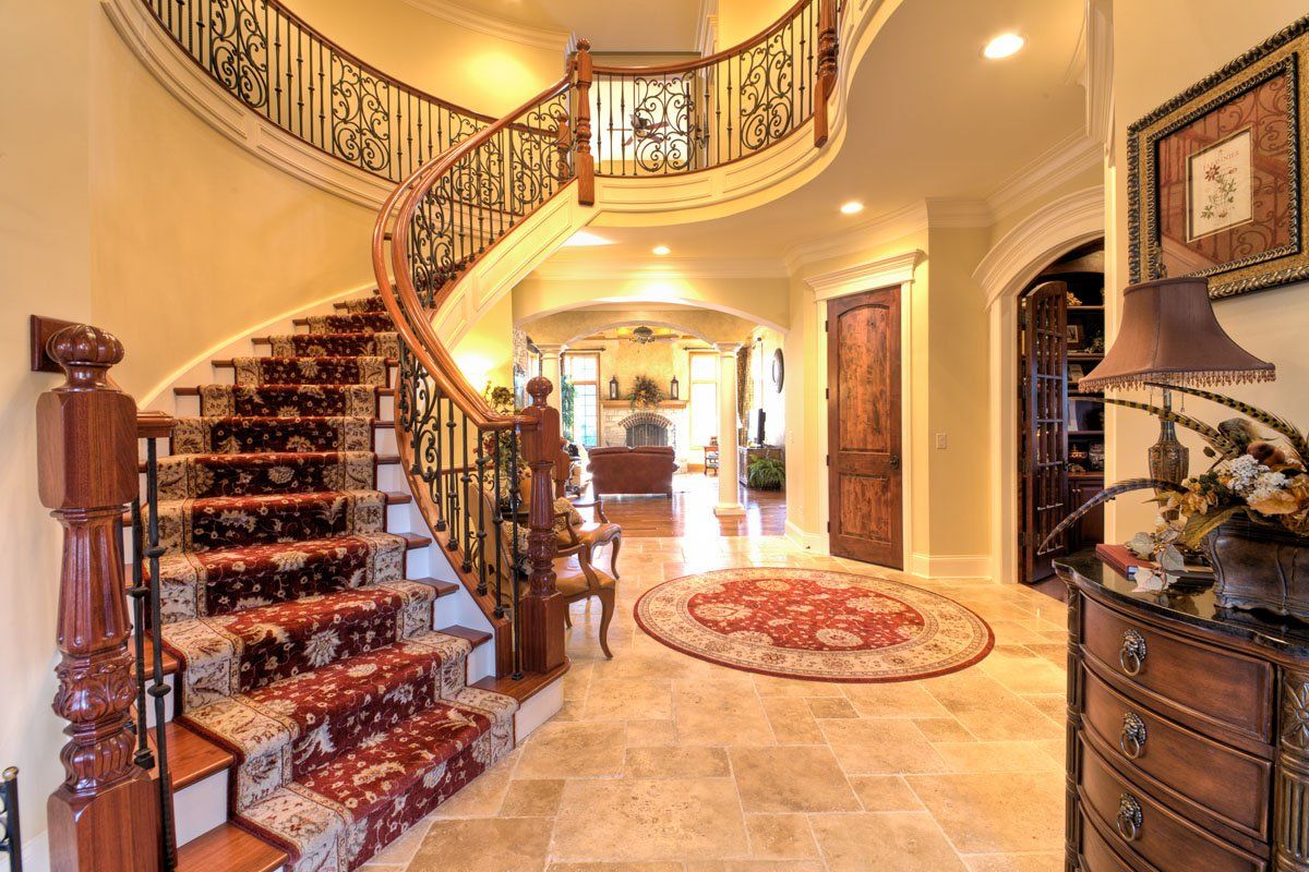 A hallway with a spiral staircase and a rug on the floor