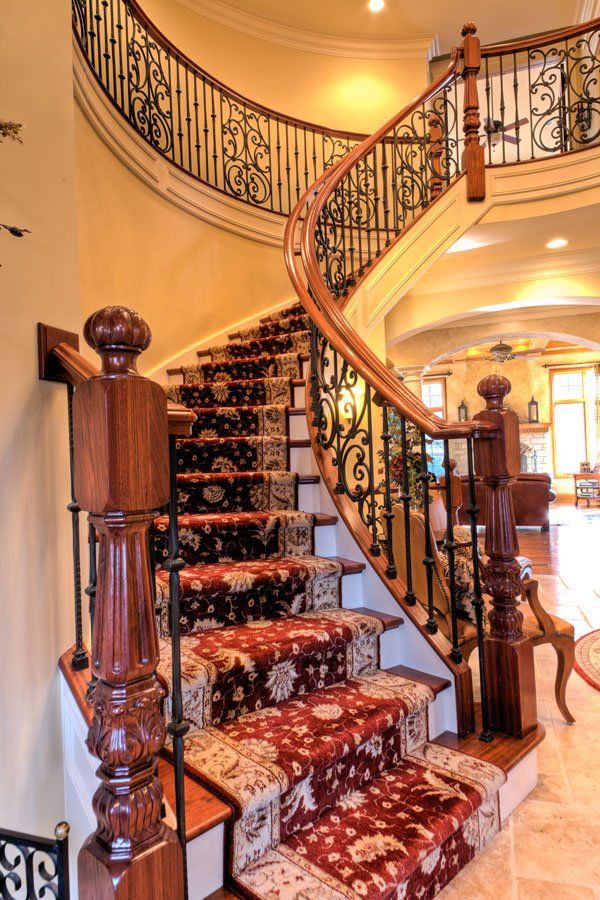 A curved staircase with a wrought iron railing in a house
