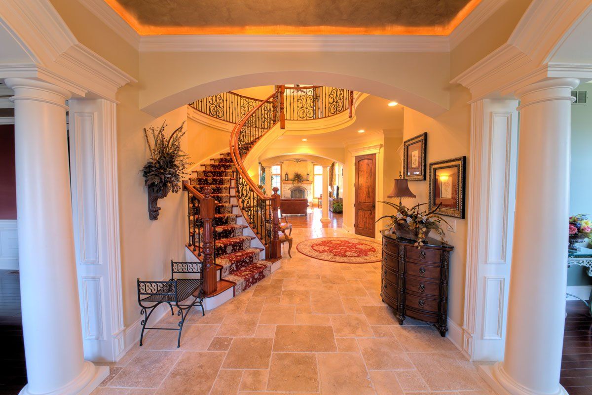 A hallway with columns and stairs in a house