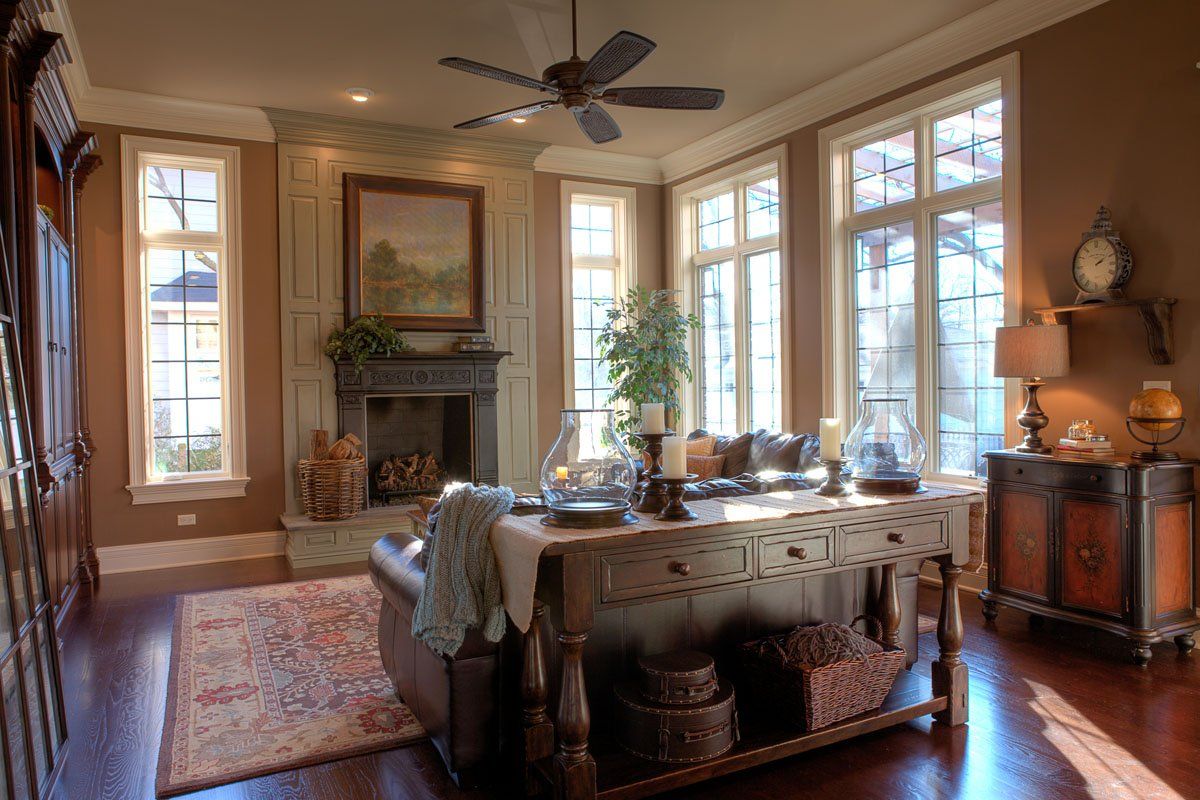 A living room with a fireplace , couch , table and ceiling fan.