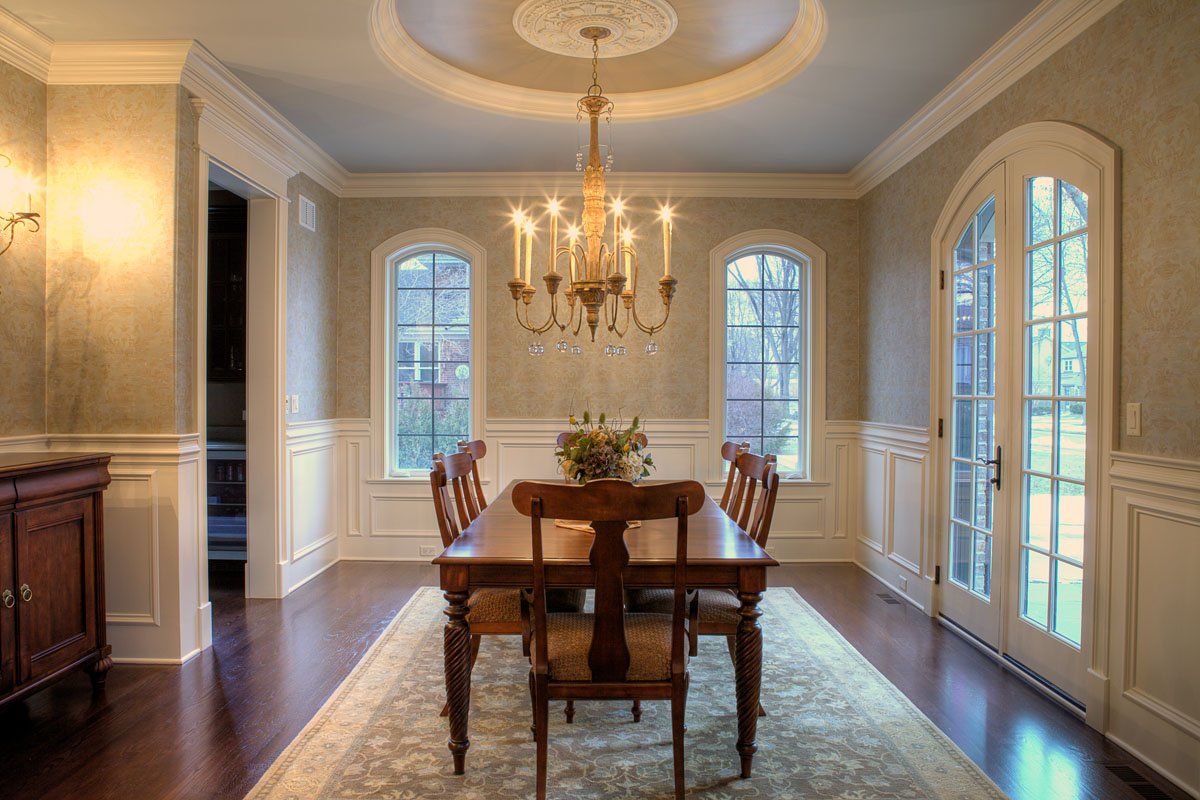 A dining room with a table and chairs and a chandelier.