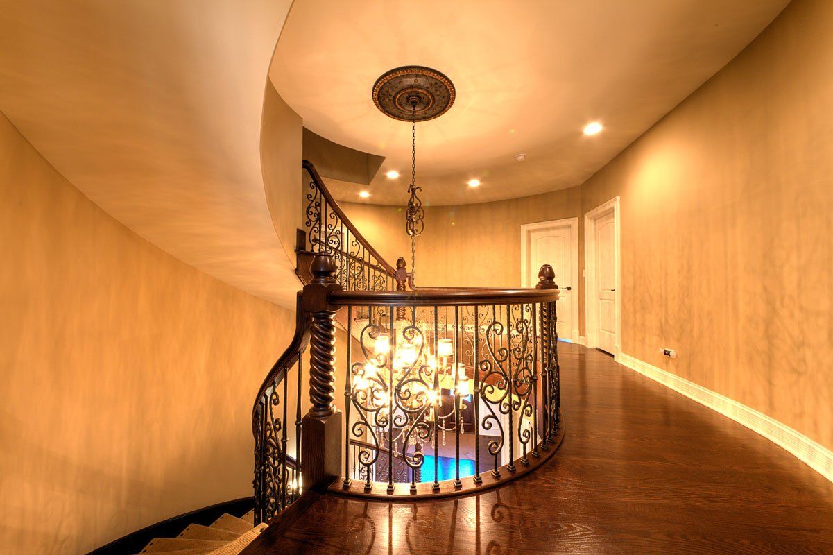 A spiral staircase with a chandelier hanging from the ceiling