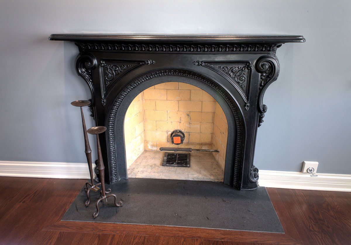 A fireplace with a black mantle in a living room