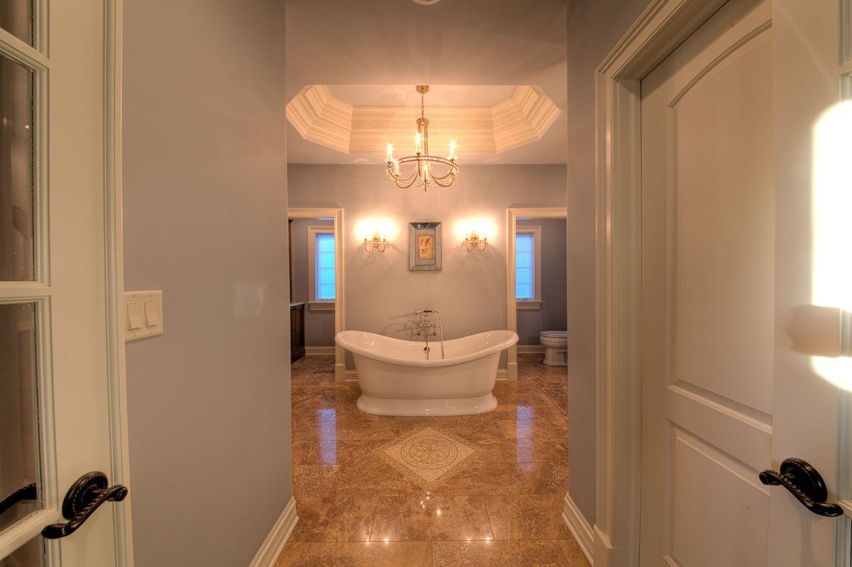 A bathroom with a bathtub and a chandelier.