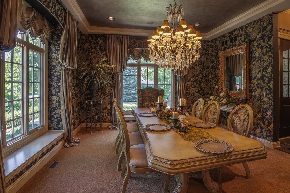 A dining room with a long table and chairs and a chandelier