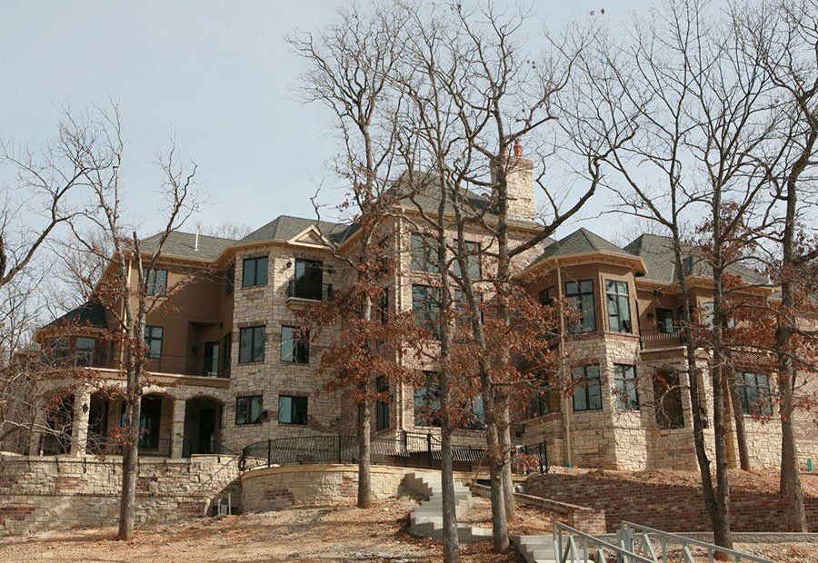A large house with a lot of windows is surrounded by trees