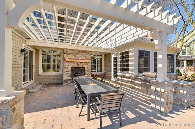A patio with a table and chairs under a pergola.