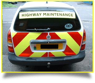 Signs on the back of a highway maintenance car