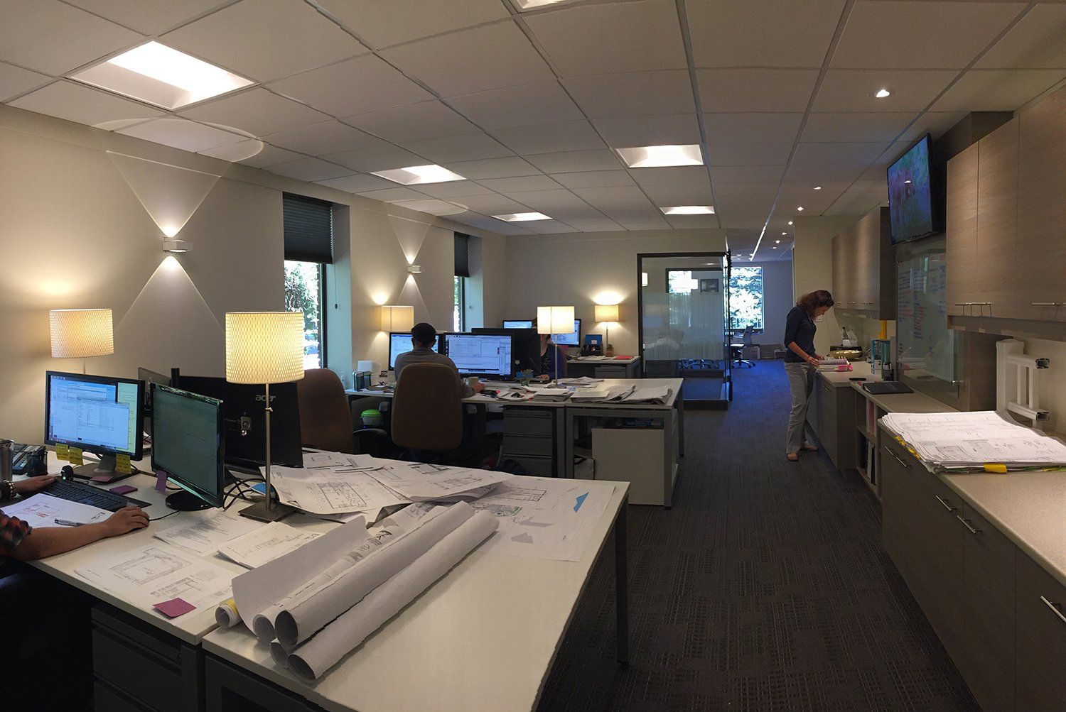 A large office with a lot of desks and computers.