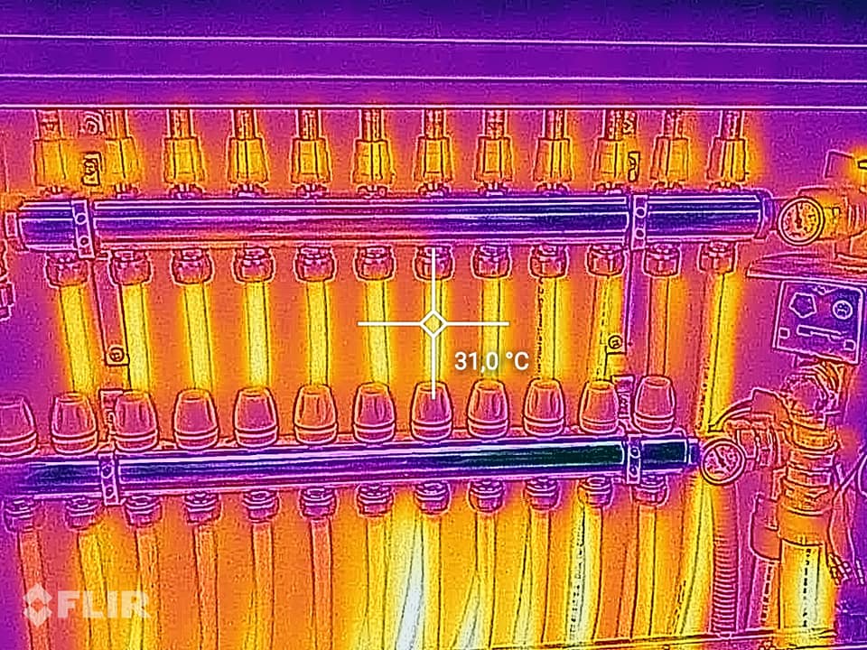 Immagine a infrarossi di una fila di tubi termici o elementi riscaldanti incandescenti all'interno di una macchina, che mostra una temperatura di 31 °C.