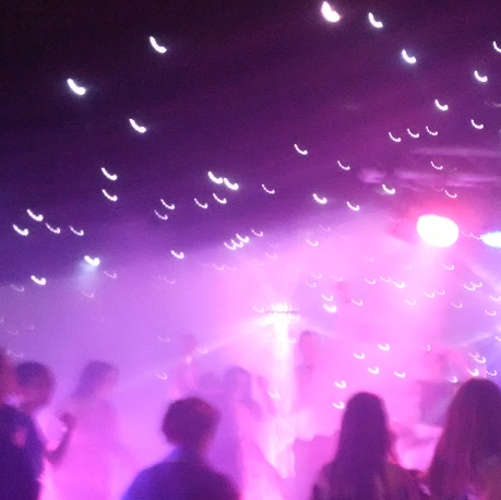 Guests on dance floor being dazzled by light show.