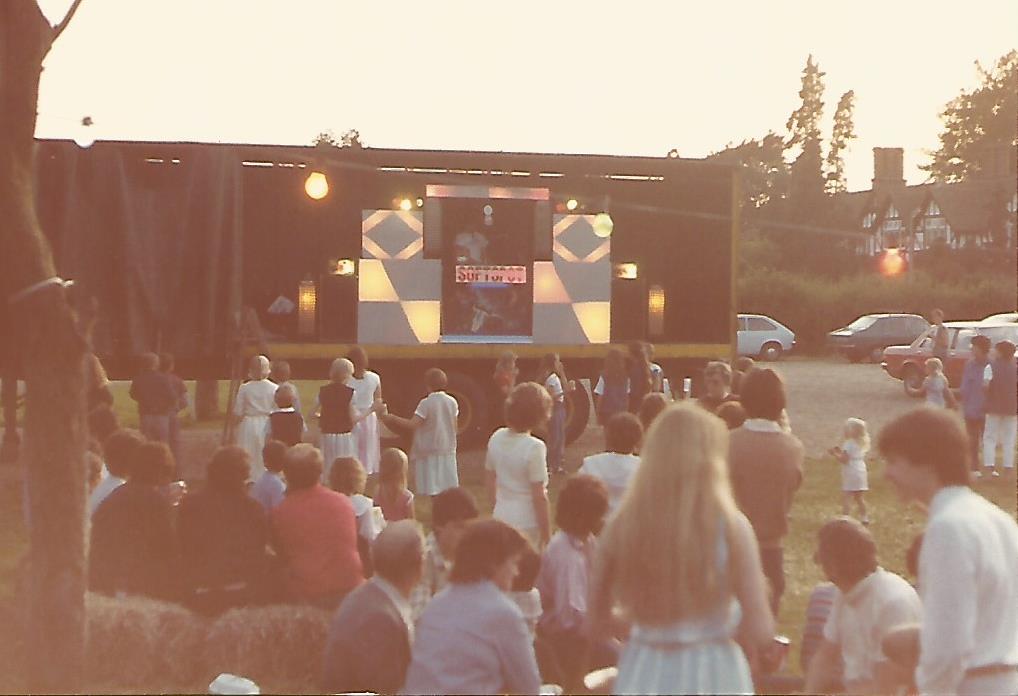 outdoor disco on a lorry trailer on village green.