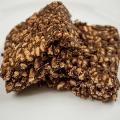 Two chocolate rice crispy treats stacked on a white plate.
