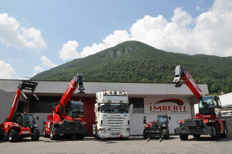 autogrù e camion davanti a una lattoneria