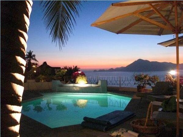 a swimming pool with a view of the ocean at night