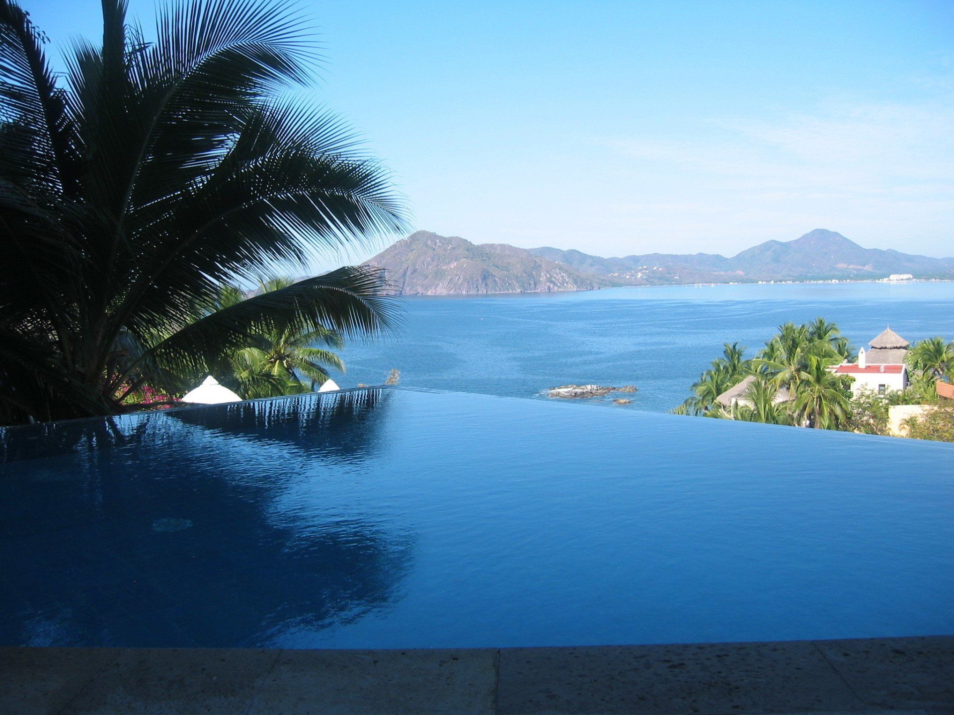 a infinity swimming pool with a view of the ocean and mountains