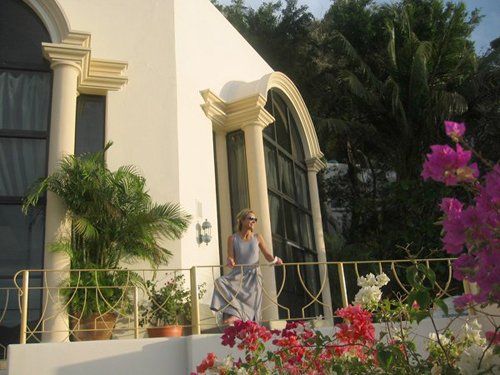 a woman is standing on a balcony in front of Casa Las Brisas Villa