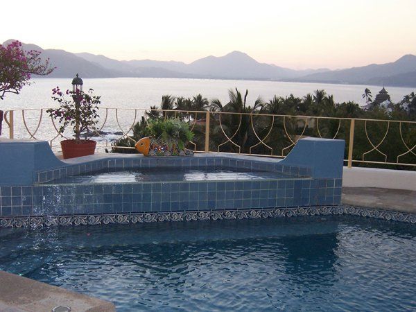 a swimming pool with a view of the ocean and mountains