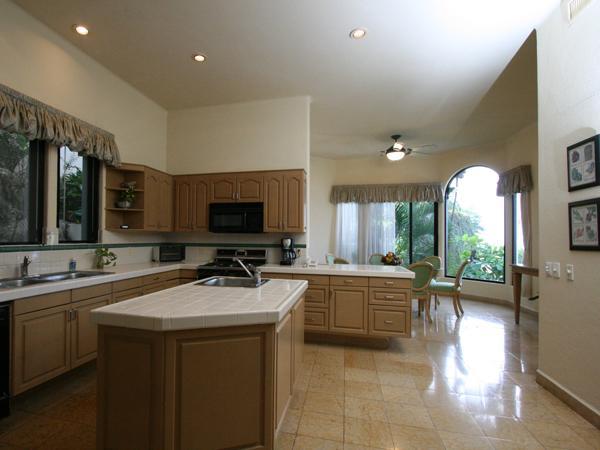 A kitchen with wooden cabinets and white counter tops