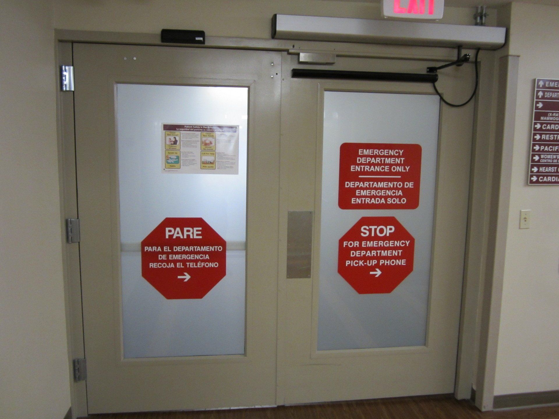Double doors with red stop signs and frosted glass in a hallway
