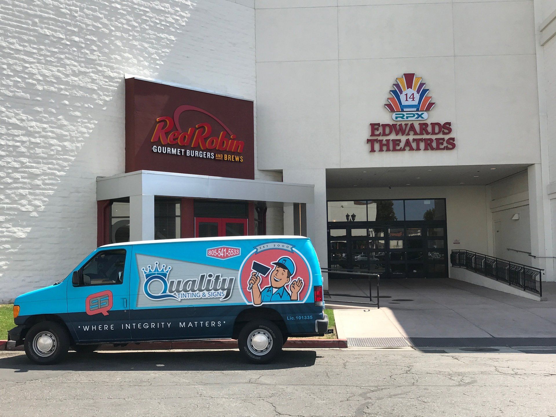 Blue Oscar Mayer Wienermobile parked outside Edwards Theatres entrance.