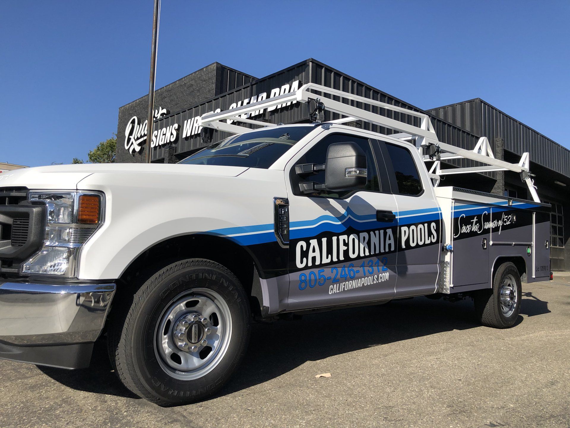 California police pickup truck parked outside a building under a clear blue sky