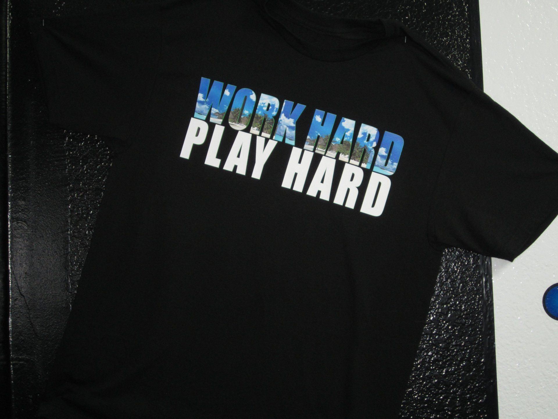 Black T-shirt with blue and white “WORK HARD PLAY HARD” text.