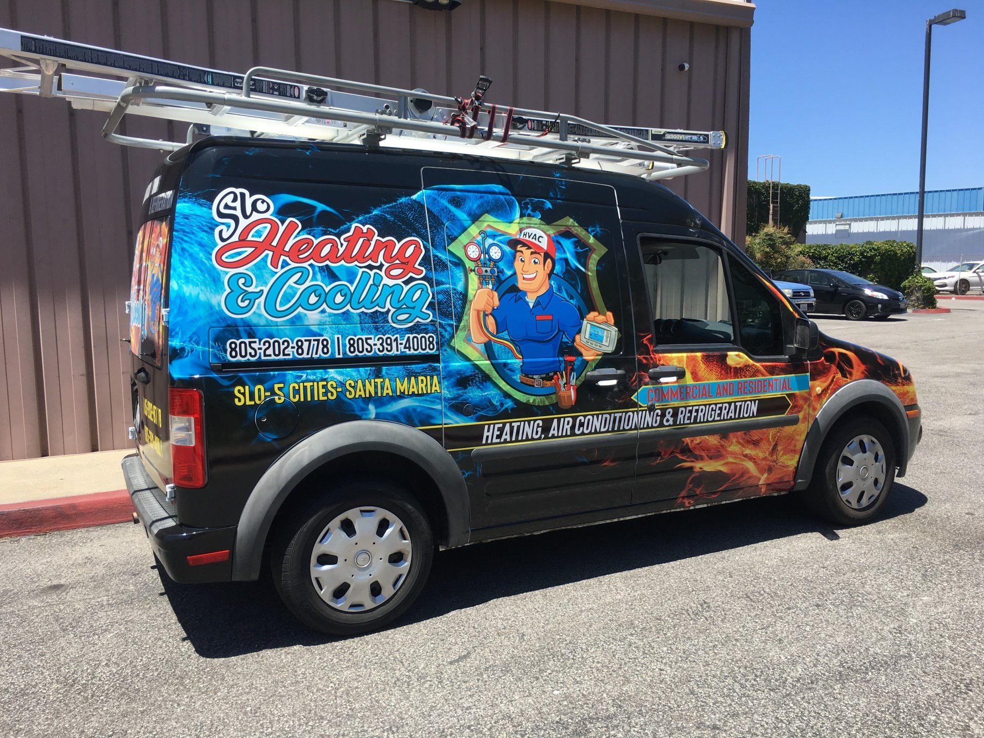 Decorated black van with a colorful “So Sassy” cleaning service mural parked outside a building