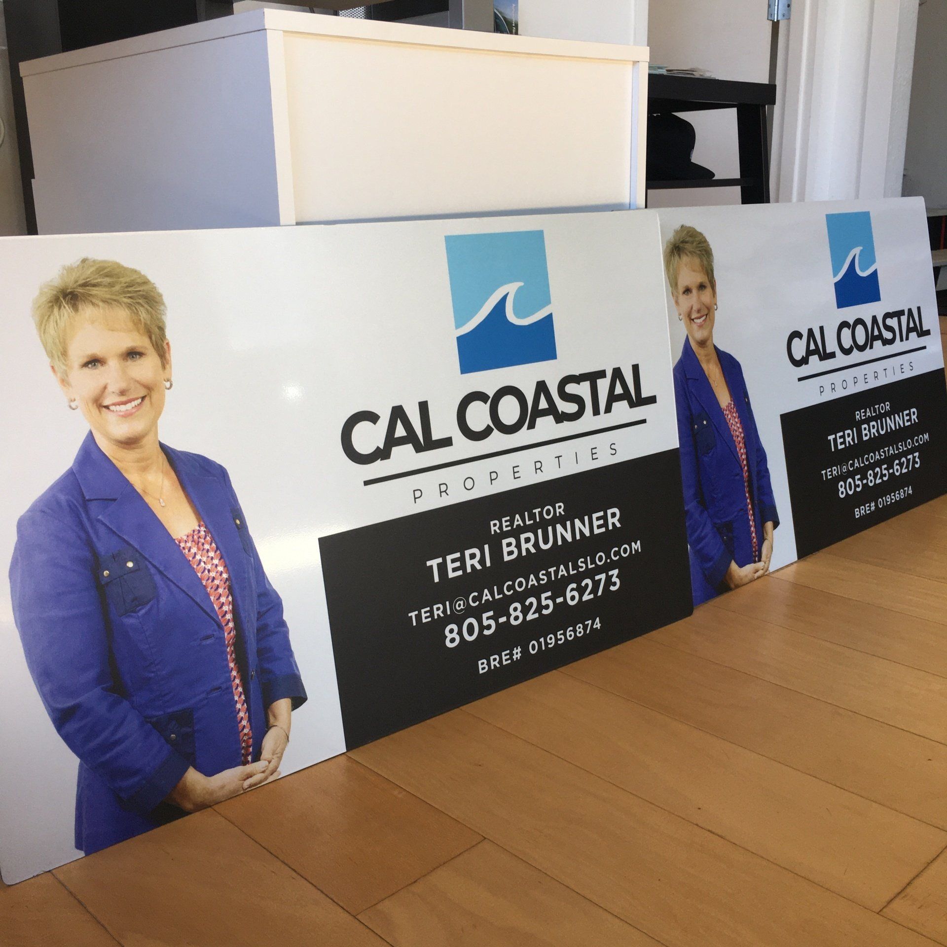 CAL COASTAL campaign signs with a woman’s portrait and Teri Brunner contact info on a wooden floor