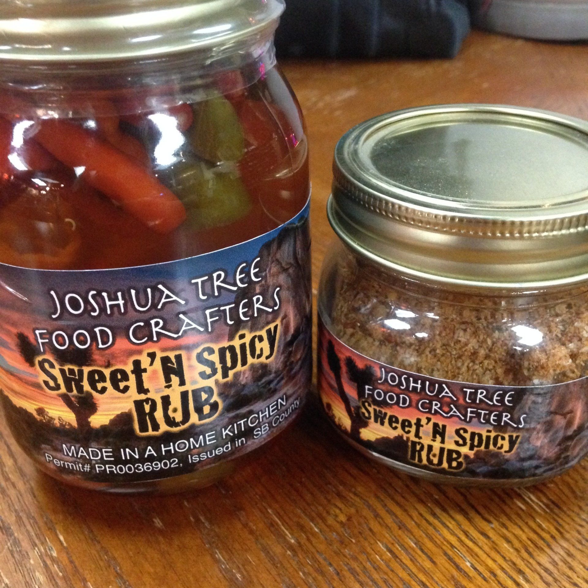 Two jars of Joshua Tree Food Crafters Sweet & Spicy Ruby on a wooden table.
