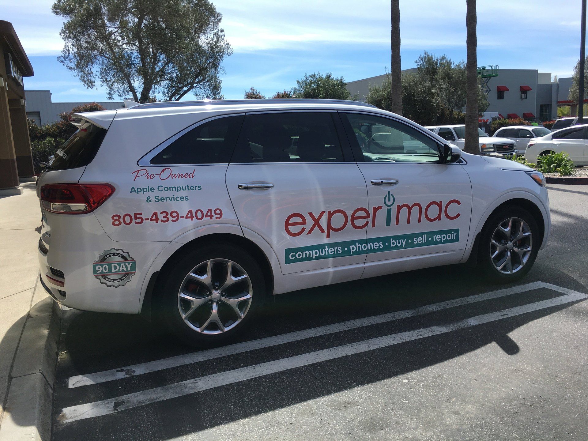 White Experimax service van parked in a lot, with company logo and phone number on the side.