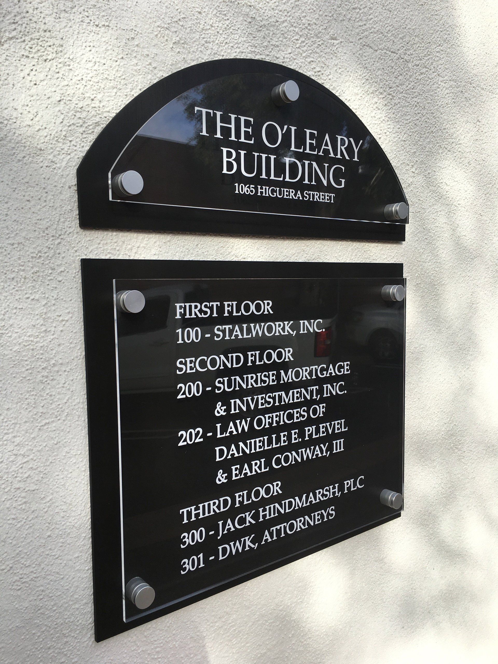 Directory sign for The Oleary Building listing floor offices on black plaques