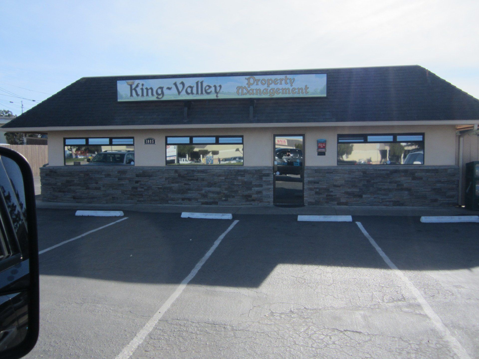 King Valley storefront with parking spaces in front and a stone facade under a dark roof.