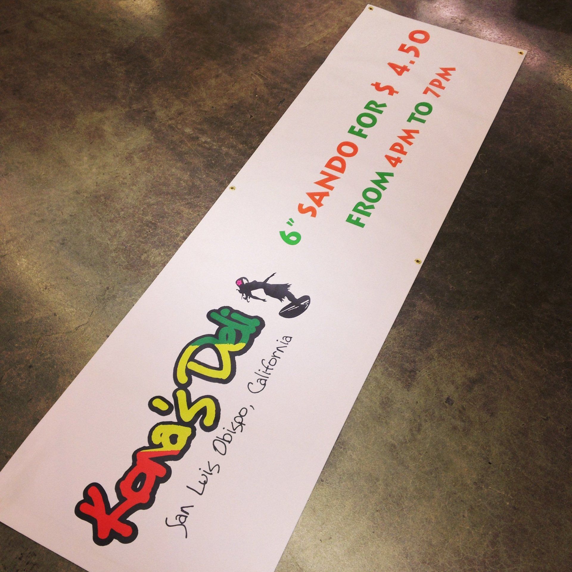 White sign for Karizma with green/red text advertising 6 sandwiches for $1.50 from 4 pm to 7 pm.