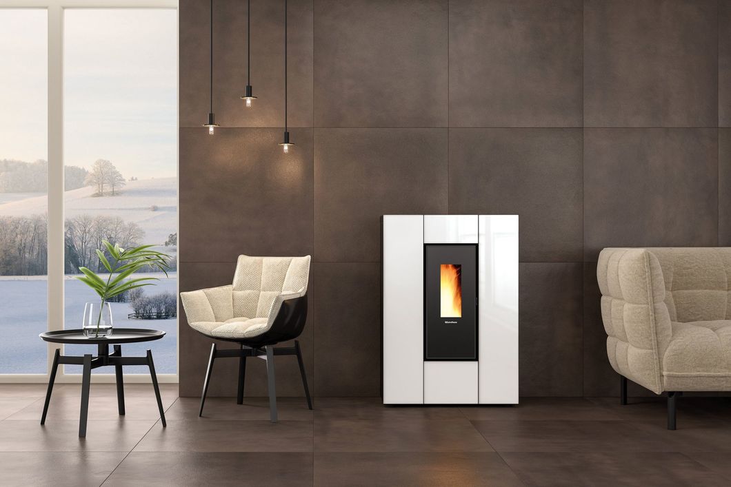 Soggiorno moderno con stufa a pellet bianca, poltrone beige, parete scura e ampia finestra panoramica.