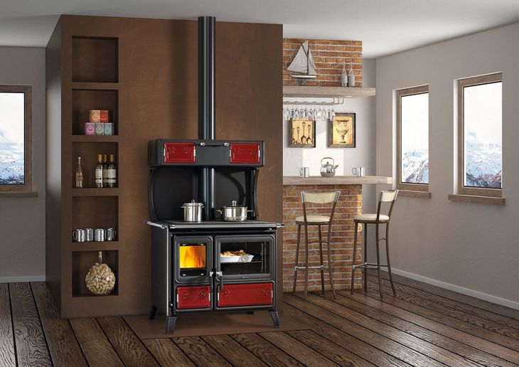 Cucina moderna con piano cottura nero, mobili in legno e tavolo da pranzo accanto a grandi finestre.