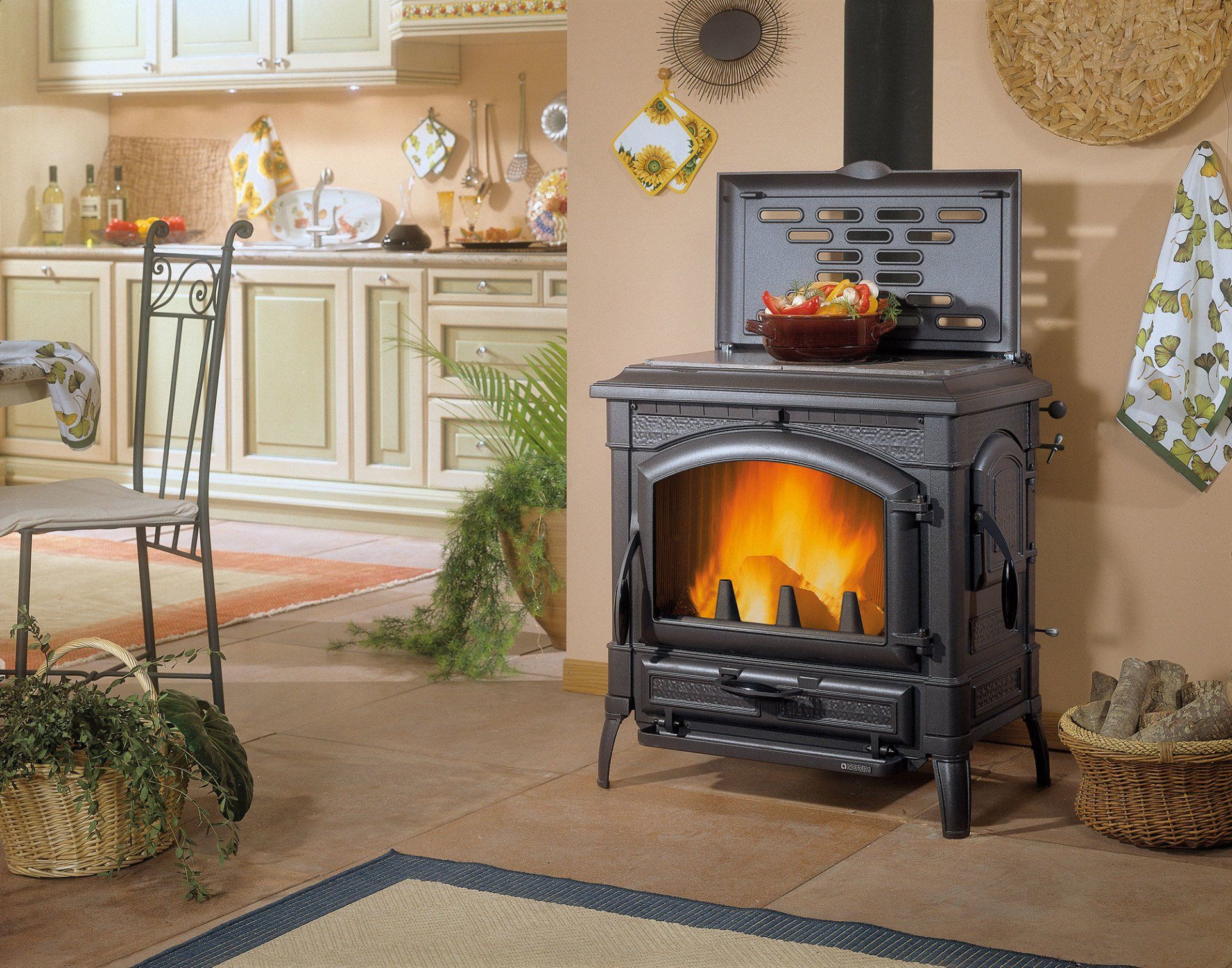 Cucina accogliente con una stufa nera accesa e una calda luce arancione, circondata da decorazioni rustiche.