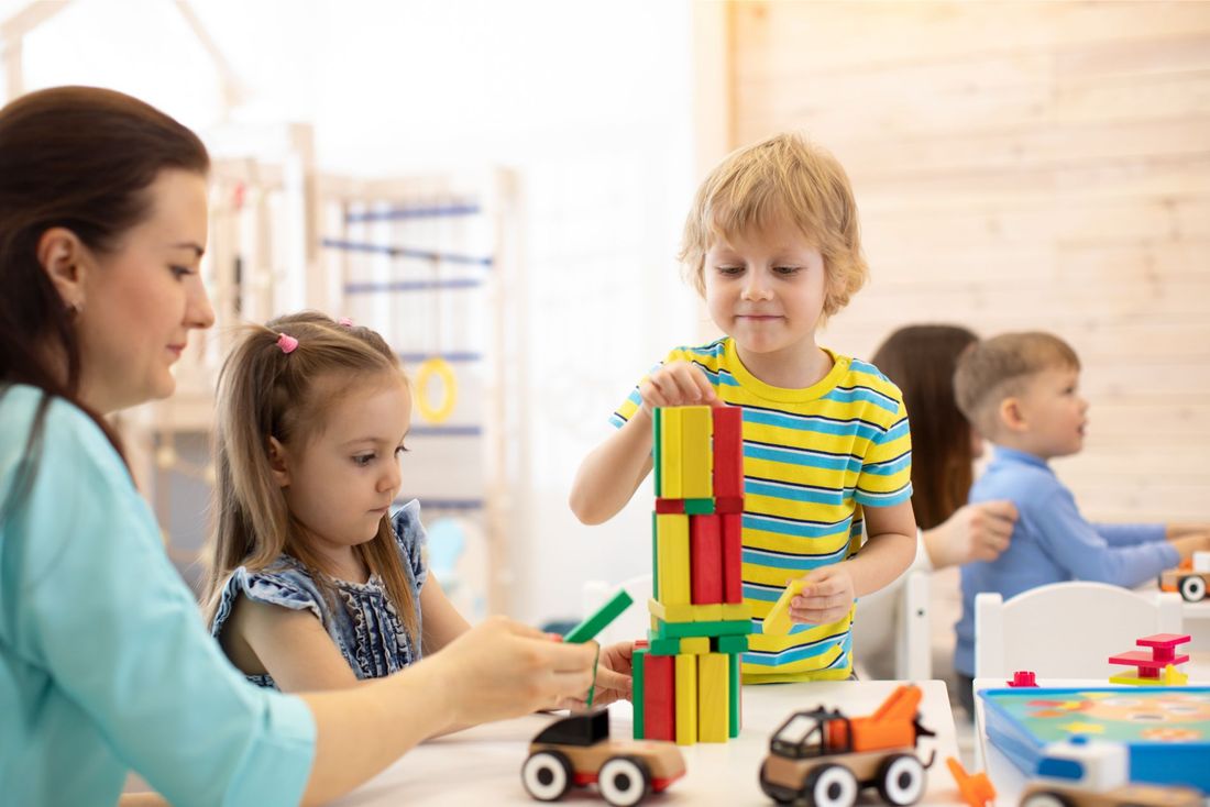 bambini mentre giocano con dei mattoncini in plastica