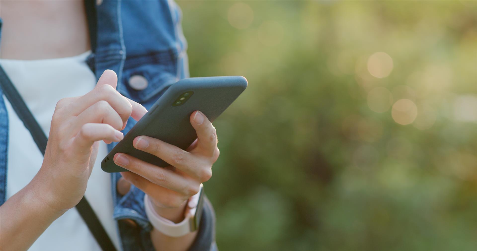 A woman is holding a cell phone in her hands.