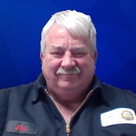 A man with a mustache is wearing a black shirt and a name tag.