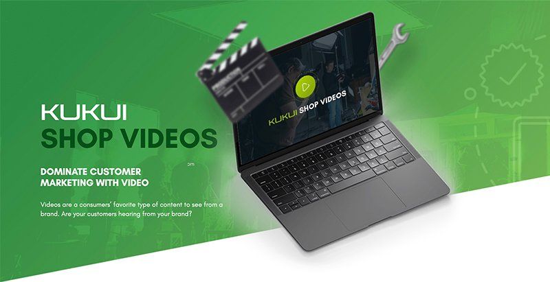 A laptop computer is sitting on a green surface next to a clapper board.