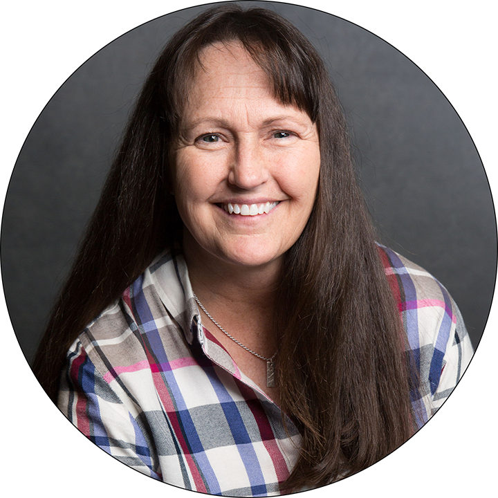 A woman in a plaid shirt is smiling in a circle
