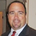 A man in a suit and tie is smiling for the camera.